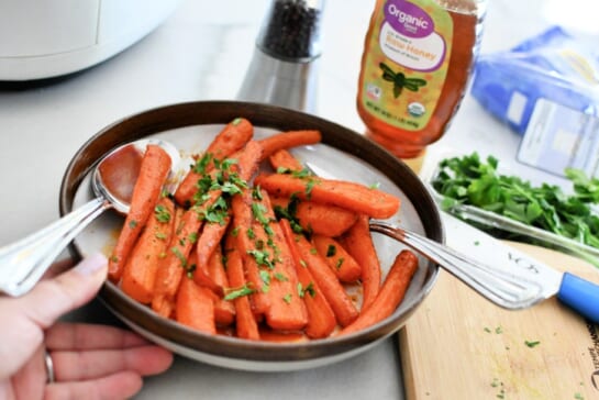 adding fresh parsley to cooked carrots
