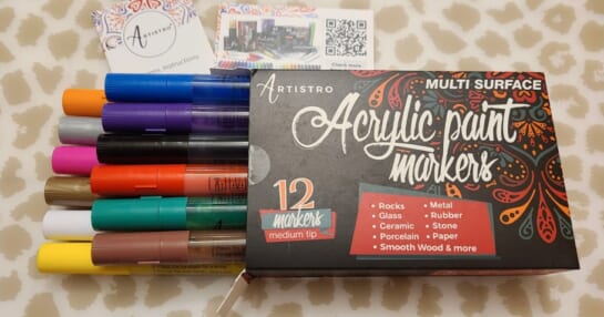 artistro arcylic paint pens box with pens coming out laying on table